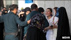 Moral Police (Ghasht e Ershad) tackle a violation of Islamic dress code in Iran in 2014.