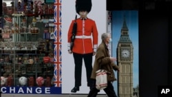 Seseorang yang memakai masker wajah berjalan melewati toko suvenir yang ditutup sementara di Oxford Street, selama restriksi virus corona kedua Inggris, di London, Senin, 23 November 2020. (Foto: AP)