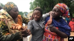 Une élève qui a été enlevée puis relâchée retrouve sa famille au lycée Bethel Baptist de Damishi, au Nigeria, le dimanche 25 juillet 2021.