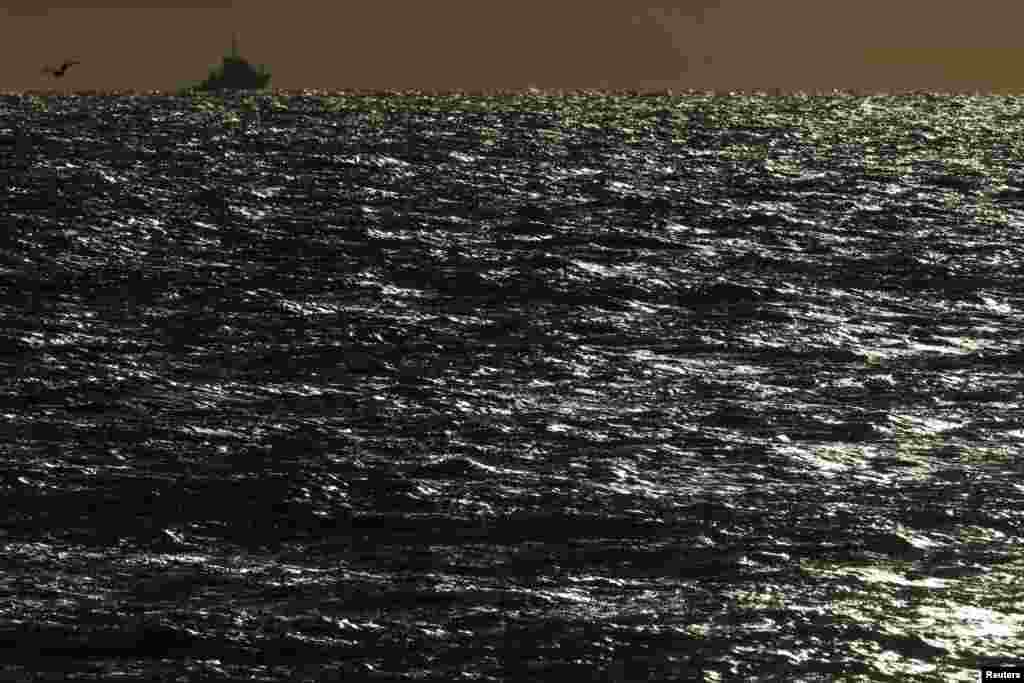 French tugboat "Abeille Languedoc" is silhouetted in the open sea near Boulogne-sur-Mer as high winds battered northern France, Nov. 4, 2013.