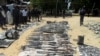 Wani dan sanda yana duba gine gine da ababan hawa da kuma makamai bayan harin da kungiyar Boko Haram ta kai a Damaturu ranar 25 da 25 ga watan Oktoba. An dauki hotunan ranar 28 ga watan Oktoba, 2013.