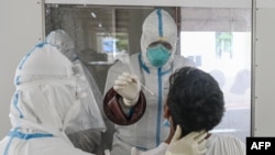 ရန်ကုန်မြို့ လှိုင်တက္ကသိုလ်ရှိ Quarantine နေရာတခုမှာ COVID 19 စစ်ဆေးပေးနေတဲ့ ကျန်းမာရေးဝန်ထမ်းများ။ (ဇူလိုင် ၁၆၊ ၂၀၂၀)