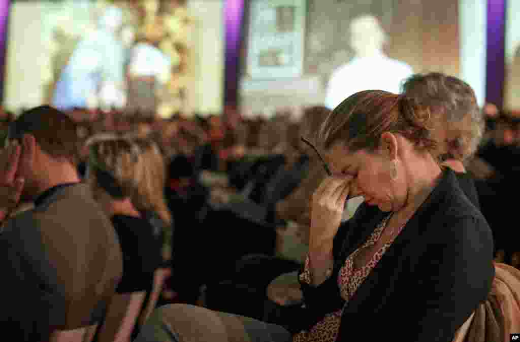Relatives and friends of the victims of the Malaysia Airlines Flight 17 disaster attend a commemoration ceremony. Images of the victims were projected on a screen at RAI in Amsterdam, Netherlands, Nov. 10, 2014.