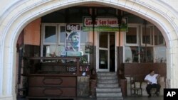 FILE - A restaurant worker sits outside his closed restaurant along the Malecon seafront after the death of former leader Fidel Castro, in Havana, Cuba, Nov. 28, 2016.