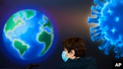 A woman wearing a face mask waits to receive a coronavirus vaccine at a COVID-19 vaccination center in Jerusalem, Monday, Jan. 4, 2021. (AP Photo/Oded Balilty)