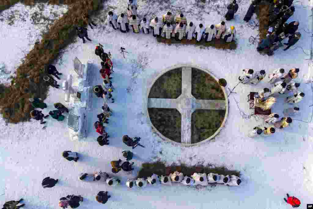 Orthodox priests conduct a religion service blessing the ice water of the Tura river during a traditional Epiphany celebration as the temperature is about -5° C (23° F) at the Holy Trinity Monastery in Tyumen, Russia.