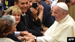 Le Pape François, à droite, salue les fidèles lors de son audience des participants au Congrès National de la Fédération Italienne des Maîtres du Travail, à Aula Paolo VI au Vatican, le 15 juin 2018.