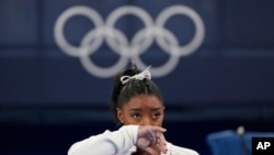  Simone Biles, de Estados Unidos, observa a las gimnastas actuar después de una aparente lesión, en los Juegos Olímpicos de Verano de 2020, el martes 27 de julio de 2021, en Tokio. Biles se retiró de la final por equipos. (Foto AP / Ashley Landis)