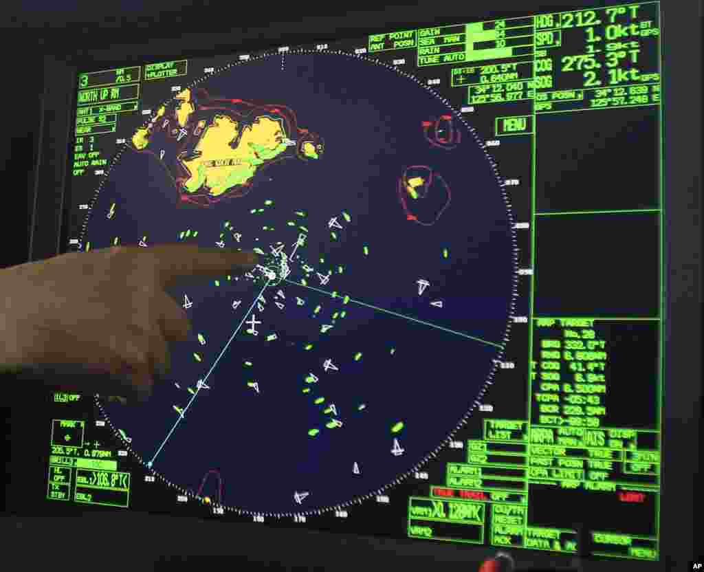 An official on a Coast Guard ship points at a radar display of the area where the ferry sank off the southern coast near Jindo, South Korea, April 17, 2014. 