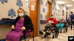 Nursing home residents make a line for the coronavirus disease vaccine at Harlem Center for Nursing and Rehabilitation, a nursing home facility, Jan. 15, 2021, in the Harlem neighborhood of New York. 