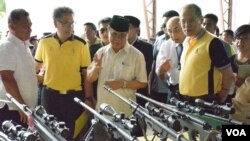 Ketua Front Pembebasan Islam Moro (MILF) Al Haj Murad Ebrahim (tengah) menunjukkan kepada Presiden Filipina Benigno Aquino (kanan) senjata-senjata yang digunakan para pemberontak dalam proses pembicaraan damai di Sultan Kudarat, provinsi Maguindanao, FIlipina, 16 Juni 2015 (Foto: dok).