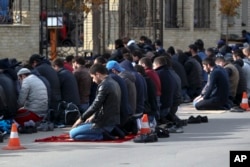 FILE - Men attend a Friday prayer at the mosque on Kotrova street in Dagestan's regional capital Makhachkala, Russia, Nov. 13, 2015.