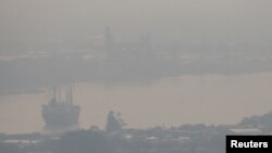 A cargo ship is seen through air pollution along the Chao Phraya river in Bangkok, Thailand, January 11, 2019. REUTERS/Athit Perawongmetha