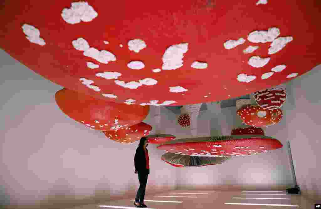 A woman looks at the installation "Upside Down Mushroom Room" by Carsten Holler, part of the Design Week, at the Prada's foundation, in Milan, Italy.