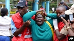 Staf Palang Merah Kenya menolong seorang perempuan yang historis setelah melihat jenazah seorang sanak keluarganya, Kamis (2/4).