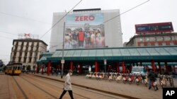 A man walks under a poster advertising the TV Series ‘Zero’, at Cadorna square in Milan, Italy, April 27, 2021.