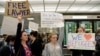 Lawyers offer free counseling as they join dozens of pro-immigration demonstrators cheering and holding signs as international passengers arrive at Dulles International Airport to protest President Donald Trump's travel ban in suburban Washington, Jan. 29