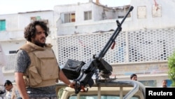 A fighter of the southern Yemeni separatists mans a machine gun mounted on a military vehicle securing an anti-government protest in Aden, Yemen, Jan. 28, 2018.