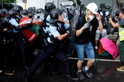 Police try to disperse protesters near a flag raising ceremony for the anniversary of Hong Kong handover to China in Hong Kong, July 1, 2019.
