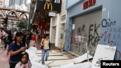 人們從香港銅鑼灣被搗毀的商店前走過。 （2019年10月8日）