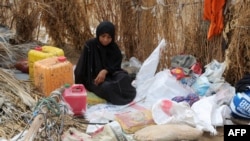 FILE - A Yemeni woman sits in the remains of a home in a neighborhood ravaged by Tropical Cyclone Sagar, in the port city of Hodeidah, Yemen, May 19, 2018. Tropical Cyclone Luban devastated the southeastern coast of Yemen earlier this week.