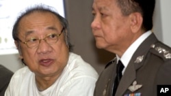 Hassadin Uraipraiwan, left, talks to reporters during a press conference at the police headquarters in Bangkok, Thailand, Feb. 11, 2015. 