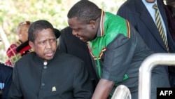 FILE - Then-acting President Edgar Lungu (l) talks to foreign affairs minister Harry Kalaba during a military exhibition march, Oct. 24, 2014 to mark Zambia's 50th Independence celebration. 