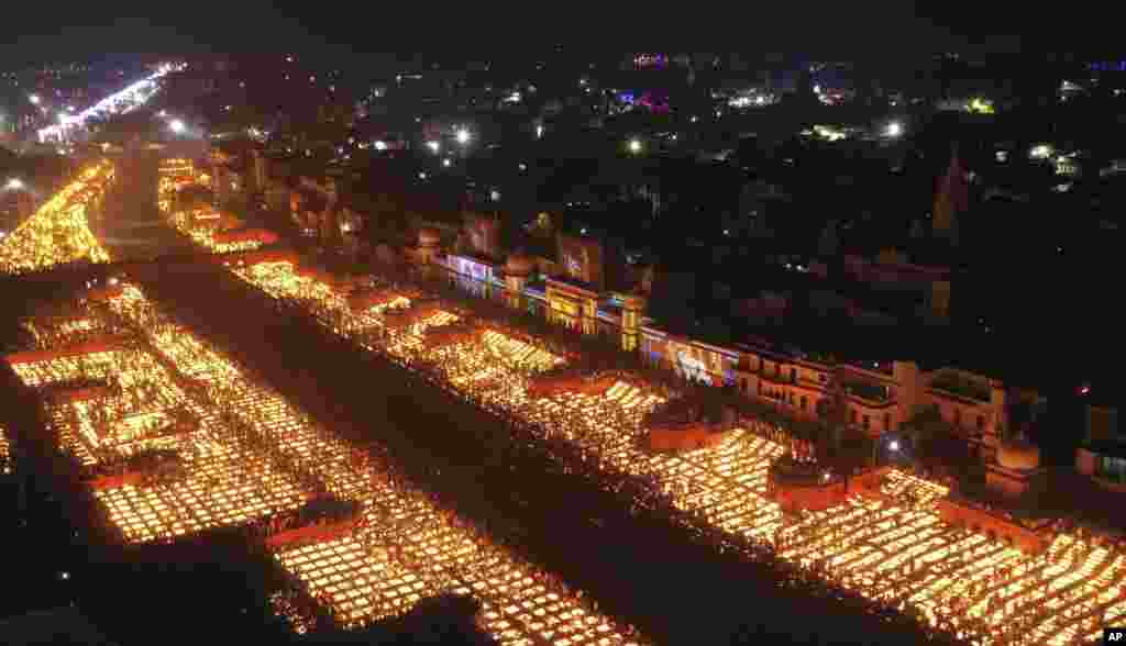 People light lamps on the banks of the river Saryu in Ayodhya, India. Over 900,000 earthen lamps were lit and were kept burning for 45 minutes as the north Indian city of Ayodhya retained its Guinness World Record for lighting oil lamps as part of the Diwali celebration – the Hindu festival of lights. 