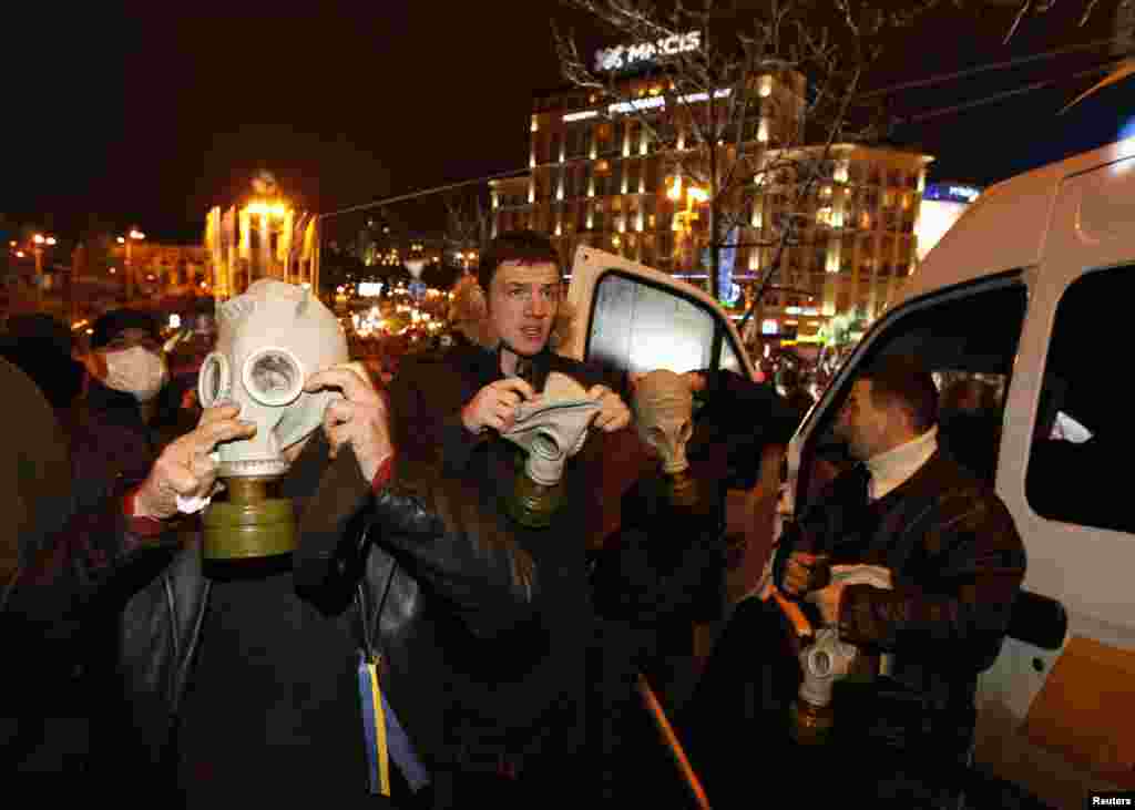 Protesters wear gas masks during a demonstration to support EU integration in Kyiv, Nov. 25, 2013.