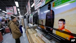 A man watches a television broadcasting a news about detained two Japanese, at an electronics store in Tokyo, Jan. 20, 2015. 