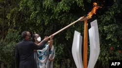 Président ya Rwanda Paul Kagame (G) na molongani wa ye Jeannette Kagame bazali kopelisa mwinda na milulu mya mibu 27 mya bobomi bonene to génocide, na Kigali, Rwanda, le 7 avril 2021.