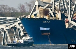 Jembatan Francis Scott Key yang runtuh terletak di atas kapal kontainer Dali di Baltimore, Maryland, pada 29 Maret 2024, saat pekerjaan pembersihan dimulai. (Foto: AFP)