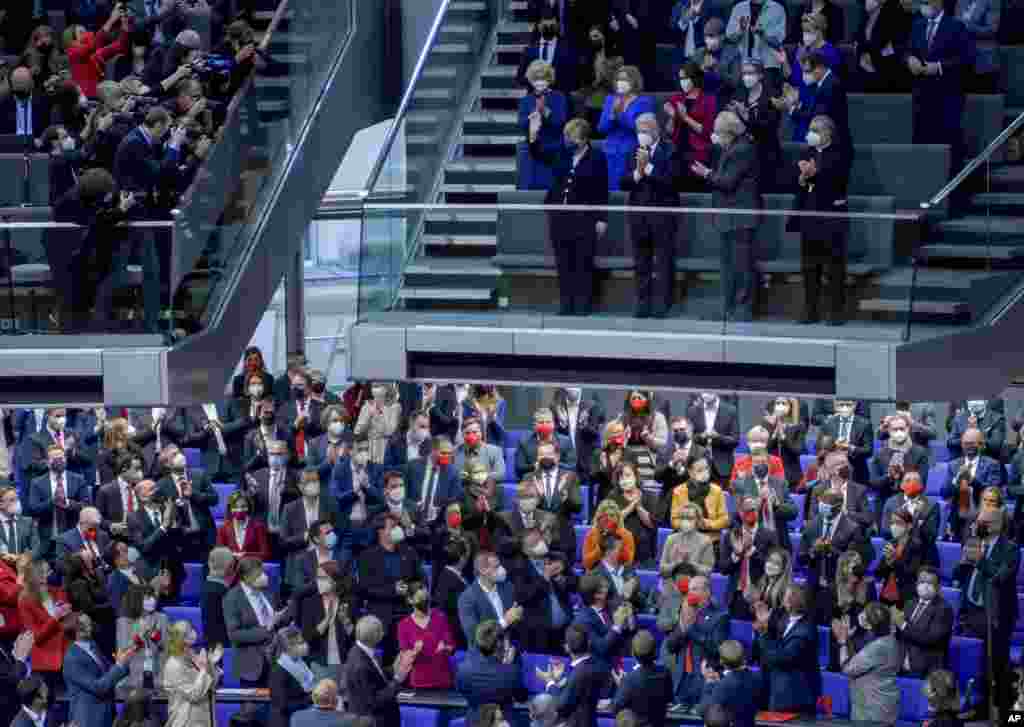 Lawmakers applaud outgoing German Chancellor Angela Merkel, center on top, in the German Parliament Bundestag in Berlin.