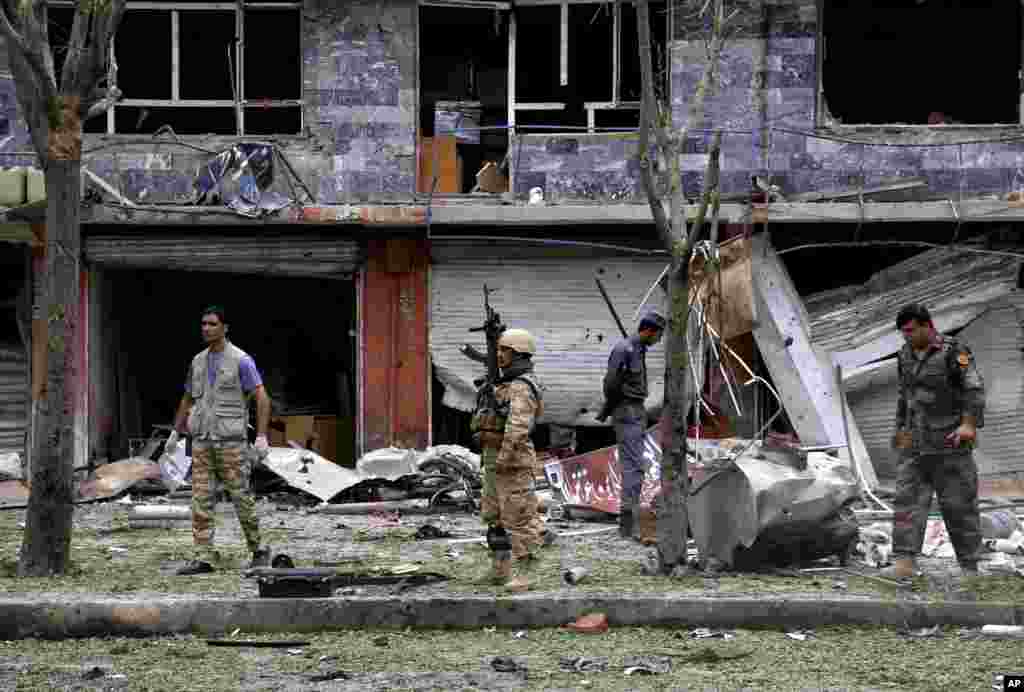 Security personnel investigate the site of a suicide attack that struck the convoy of presidential candidate Abdullah Abdullah in Kabul, June 6, 2014.