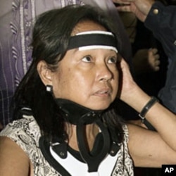 Former Philippine President Gloria Macapagal Arroyo is seen with a neck brace as she arrives on a wheelchair for a flight to Hong Kong at the Ninoy Aquino International Airport in Paranaque, Manila November 15, 2011