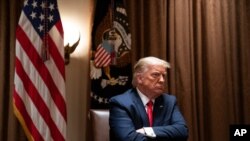 President Donald Trump listens during a meeting with Hispanic leaders in the Cabinet Room of the White House, July 9, 2020, in Washington. 