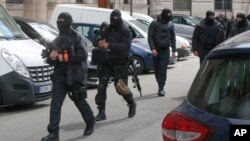 Policías franceses encapuchados vigilan la entrada de la sede de la policía judicial, parte del Palacio de Justicia, en París, Francia, el miércoles, 27 de abril de 2016.
