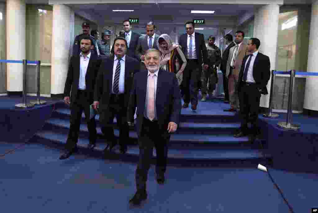 Ahmad Yousuf Nouristani, chairman of Afghanistan's Independent Election Commission, center arrives for a press conference in Kabul, Afghanistan, Sept. 21, 2014.