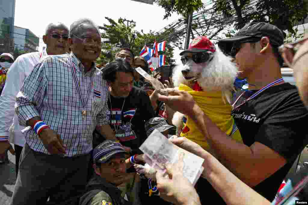 Pemimpin demonstran anti pemerintah Suthep Thaugsuban menerima donasi dari pendukung ketika memimpin pawai protes di Bangkok, 19 Januari 2014.