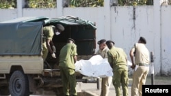 Les forces de sécurité tanzaniennes retirent le corps d'un agresseur qui brandissait un fusil d'assaut, devant l'ambassade de France dans la région de Salenda à Dar es Salaam, en Tanzanie, le 25 août 2021.