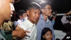 Dua wartawan Radio Free Asia Uon Chhin (tengah), dan Yeang Socheamet (kanan), bersama-sama di penjara Prey Sar di pinggiran Phnom Penh, Kamboja, Selasa, Agustus. 21, 2018. (Foto: dok).