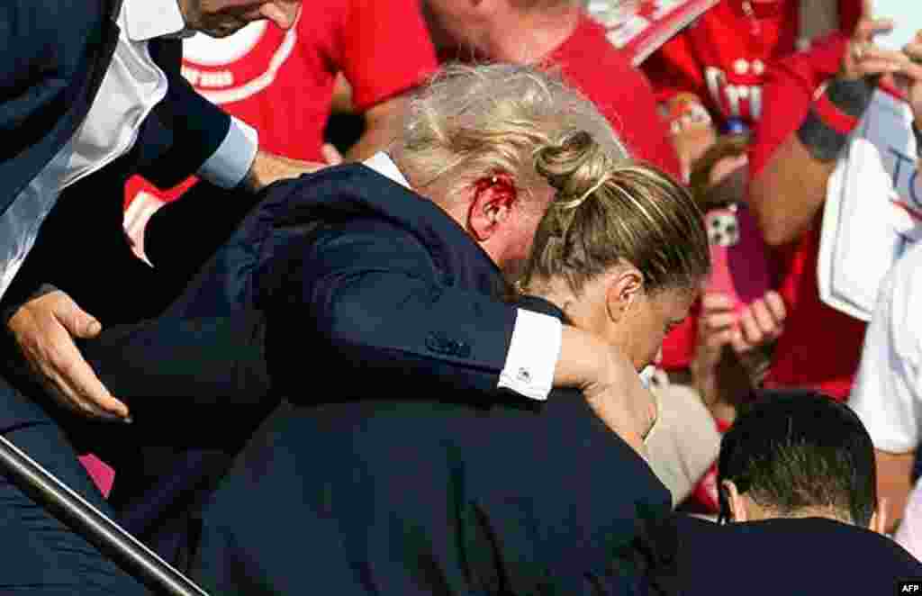 Donald Trump amemami na bakengeli ba ye nsima na kozoka na litoyi na masasi abetamaki na meeting na Pennsylcanie, 13 sanza ya sambo 2024. AFP