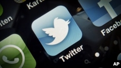 An icon for the Twitter application is seen on a mobile phone. 