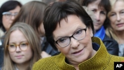Polish Prime Minister Ewa Kopacz of the Civic Platform party speaks with journalists after meeting with a group of women in Warsaw, Oct. 23, 2015, on the last day of campaigning before Sunday's parliamentary elections.