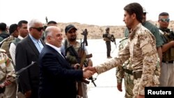 Iraqi Prime Minister Haidar al-Abadi, left, who was touring Anbar province, visiting army units, shakes hands with a Sunni tribesman at Camp Habbaniyah, in the eastern city of Ramadi, April 8, 2015. 