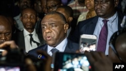 FILE - Congolese opponent Jean-Pierre Bemba, center, speaks to the press after applying to be a candidate for next presidential elections of December 23, at the office of the Independent Electoral Commission, in Kinshasa, Aug. 2, 2018.