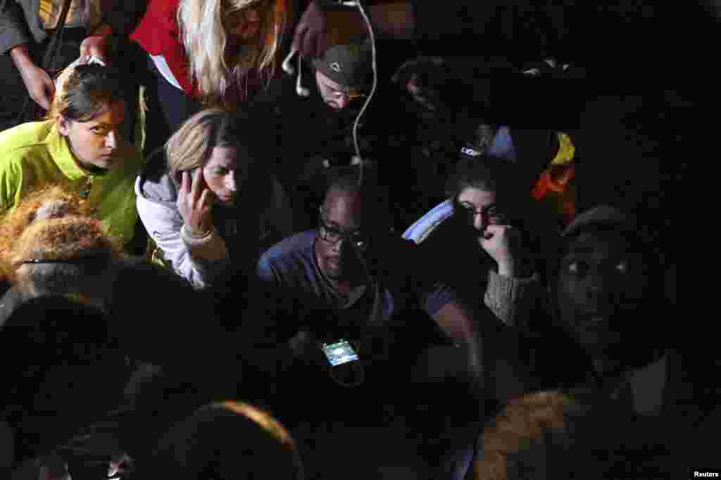 People listen to a radio as South African President Jacob Zuma announces the death of former South African President Nelson Mandela in Houghton, Dec. 5, 2013.