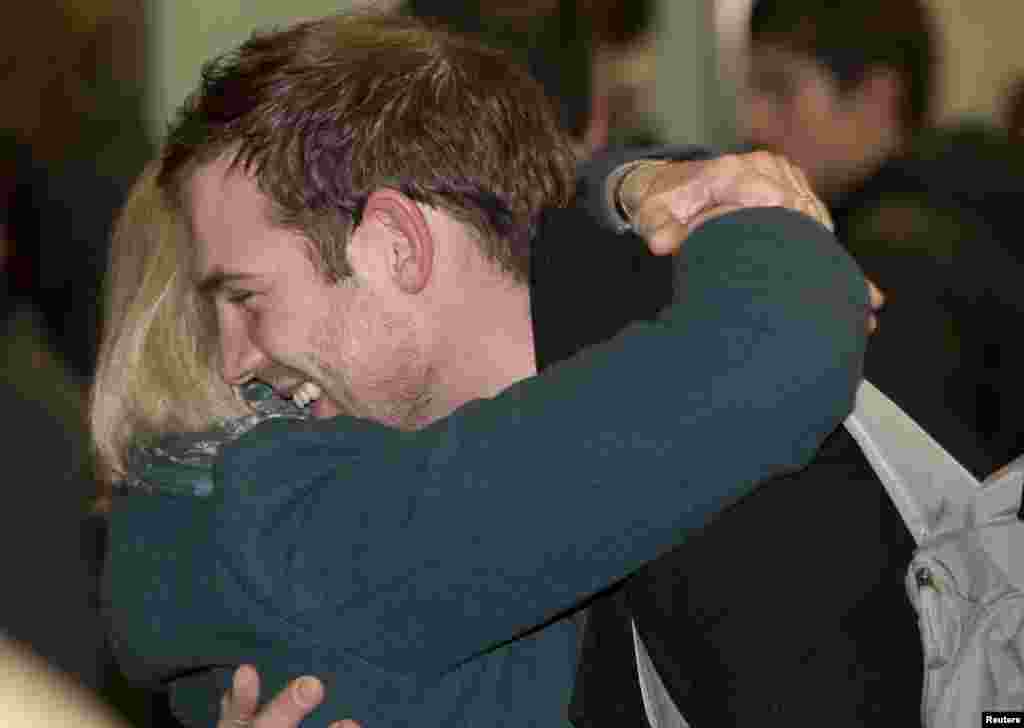 Video cameraman Kieron Bryan hugs his mother Ann after arriving at St. Pancras station in central London, England, Dec. 27, 2013.