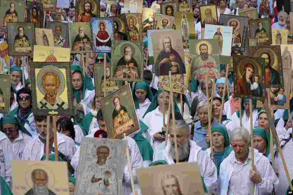 Orthodox believers carry icons as they take part in a procession along Nevsky Prospect to mark the 300 years anniversary of the Alexander Nevsky Monastery in St. Petersburg, Russia, Sept. 12, 2024.