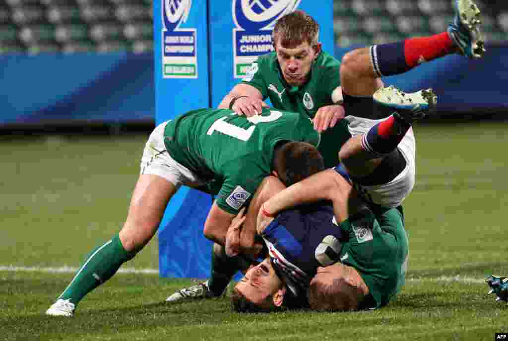Francois Bouvier (C) of France is held up over the try line by Ireland's Ryan Foley (L), Stephen Gardiner (R) and Garry Ringrose (behind) during the U20 Junior World Championship rugby union match at Albany Stadium in Auckland, New Zealand.